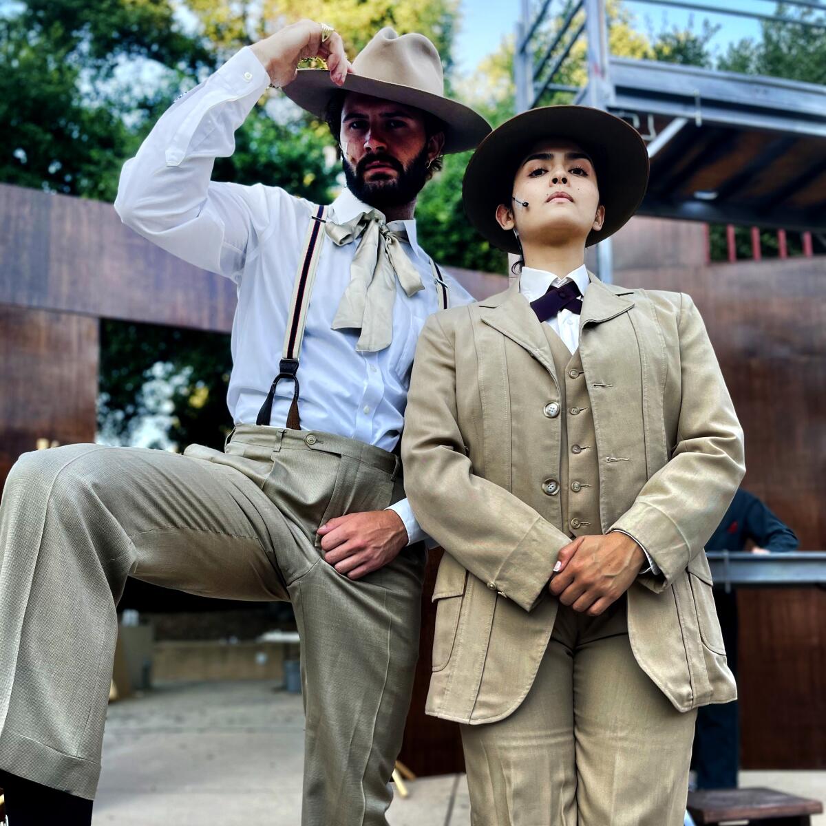 Two people dressed in period suits.