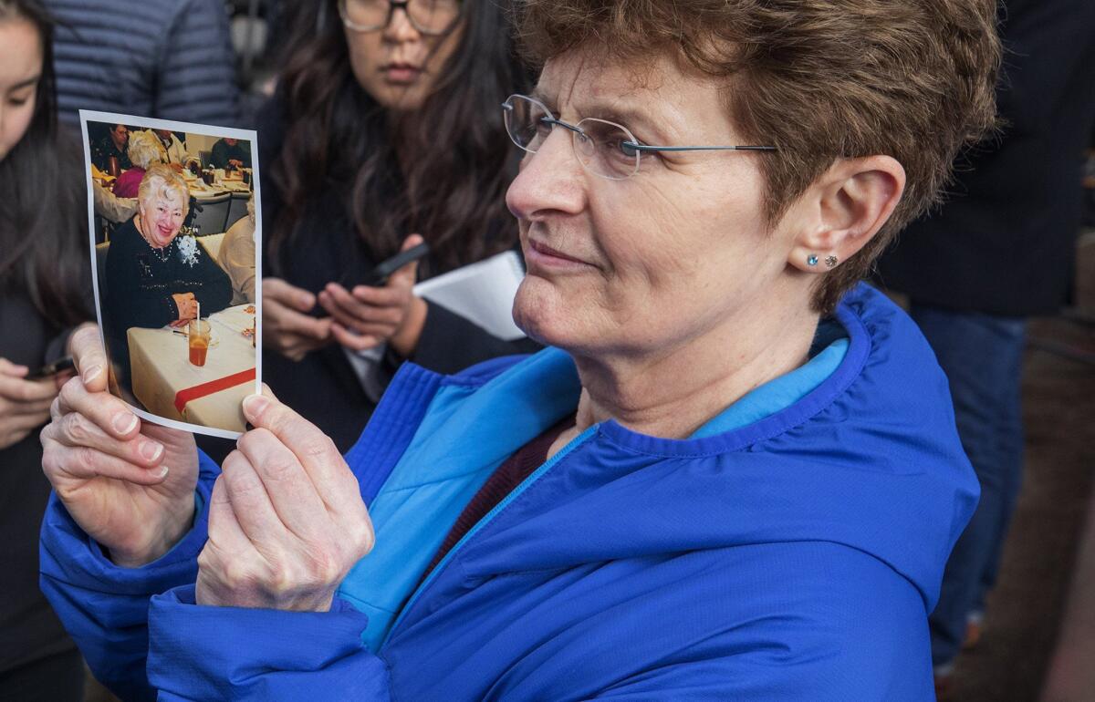 Pat Herrick holds a photo of her mother, Elaine, a resident of Life Care Center in Kirkland, Wash., who died earlier in the day on Thursday.
