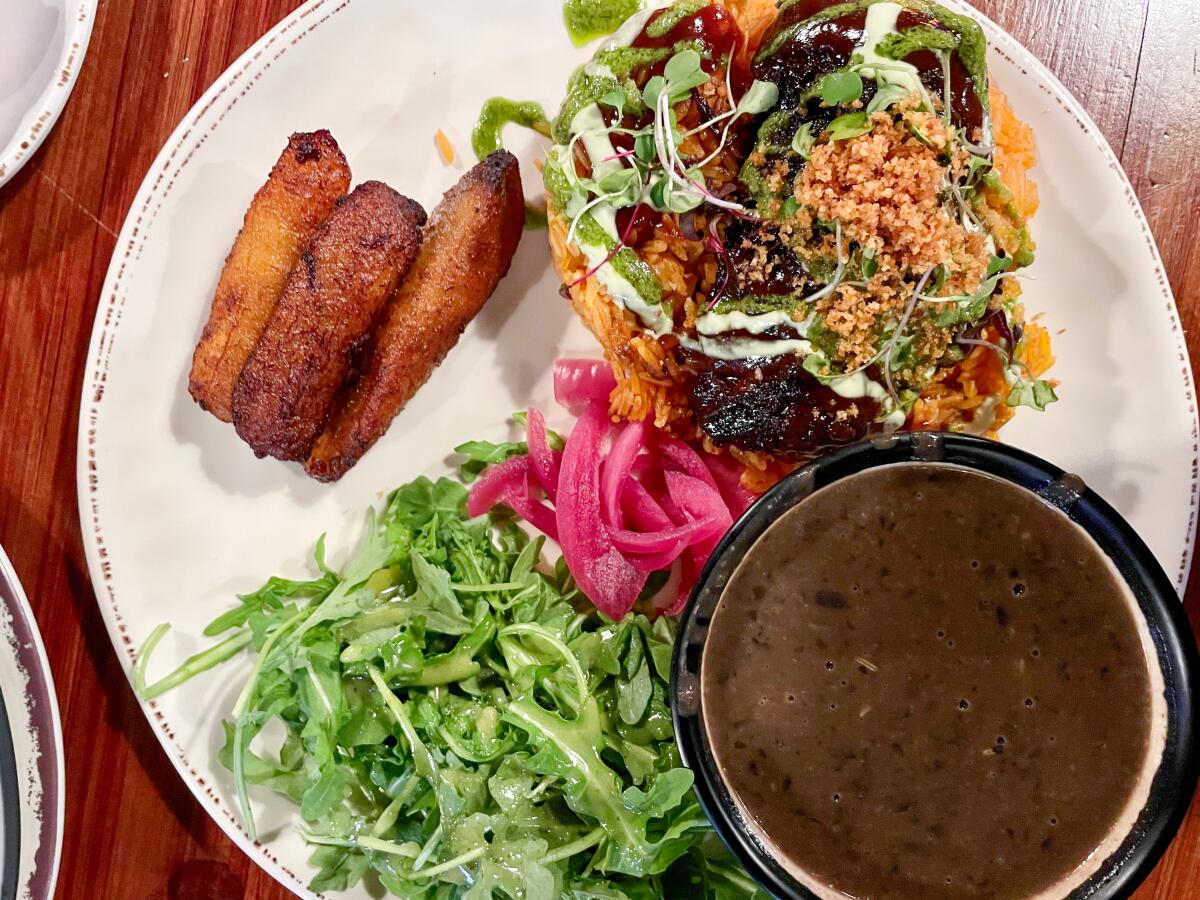 Plato de arroz Jollof con costillas estofadas en cerveza de raíz de Two Hommés.