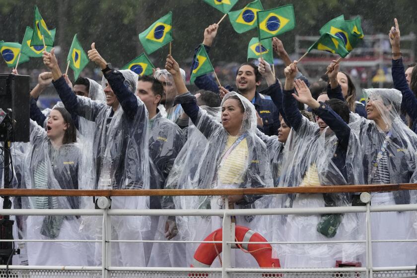 El equipo brasileño desfila sobre el río Sena con ponchos debido a la amenza de lluvia durante la inauguración de los Juegos Olímpicos de París 2024 el viernes 26 de julio del 2024. (AP Foto/Morry Gash, Pool)