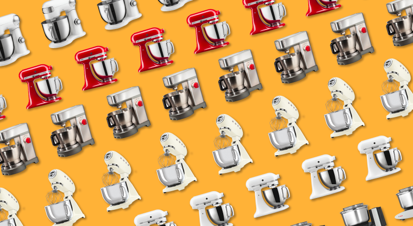 Row of various stand mixers arranged in front of an orange background