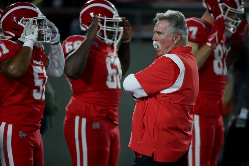 SANTA ANA, CALIF. - OPCT. 7, 2022. Mater Dei head coach Bruce Rollinson watches his team warm up before the game against St. John Bosco at Santa Ana Stadium on Friday night, Oct. 7, 2022. (Luis Sinco / Los Angeles Times)