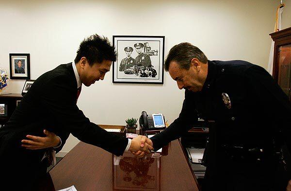 Deputy Chief Charlie Beck bows as he says goodbye to John Yang in his office at the new police administration building. Yang, a staff writer for the Korea Times, just concluded an interview with Beck. Since Beck was nominated as chief, he has been out in the community meeting and greeting different constituents and doing many interviews.