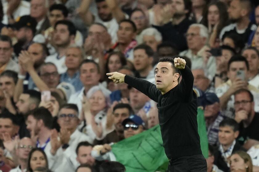 Barcelona's head coach Xavi Hernandez gestures during the Spanish La Liga soccer match between Real Madrid and Barcelona at the Santiago Bernabeu stadium in Madrid, Spain, Sunday, April 21, 2024. (AP Photo/Jose Breton)