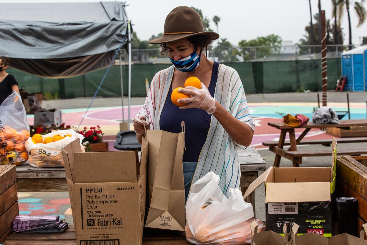 Beryl Forman sorts and bags donated fruit in City Heights to hand out to residents in need at a fruit swap Wednesday.