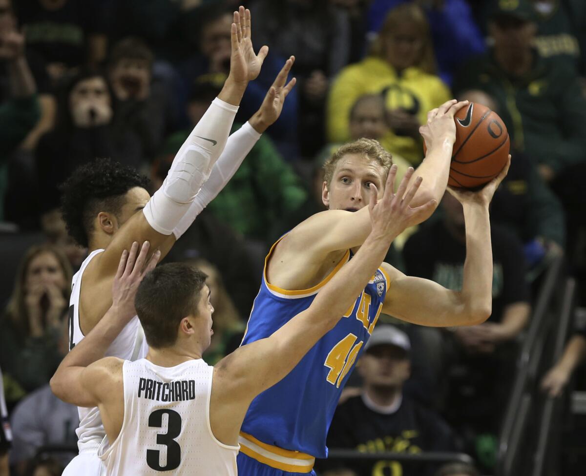 Oregon's Dillon Brooks, left, and Payton Pritchard pressure UCLA forward Thomas Welsh during the first half on Dec. 28.