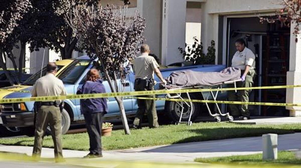 Authorities remove a body from a residence in the 31000 block of Iron Circle in Temecula.
