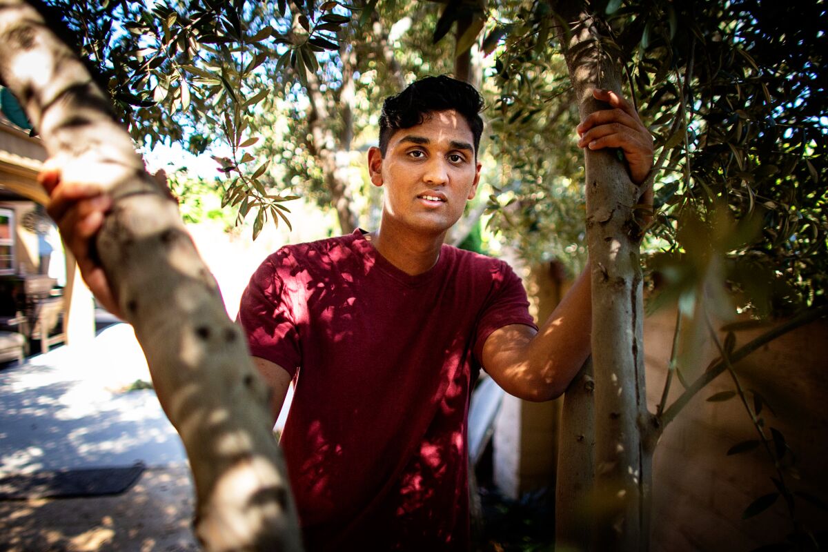 Janak Bhakta, 17, of Tustin poses for a portrait in his backyard.