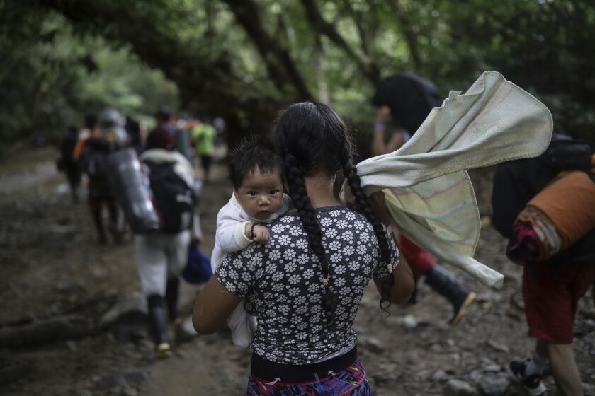 Una migrante boliviana carga un bebé mientras cruza el Tapón del Darién, de Colombia a Panamá, con la esperanza final de llegar a Estados Unidos, el 9 de mayo de 2023. (AP Foto/Iván Valencia)