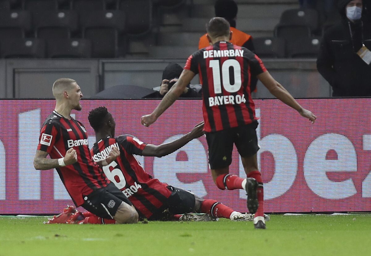 Leverkusen's midfielder Robert Andrich, left, celebrates with teammates after scoring his side's first goal during the Bundesliga soccer match between Hertha BSC and Bayer Leverkusen at the Olympiastadion in Berlin, Germany, Sunday Nov. 7, 2021. (Andreas Gora/dpa via AP)