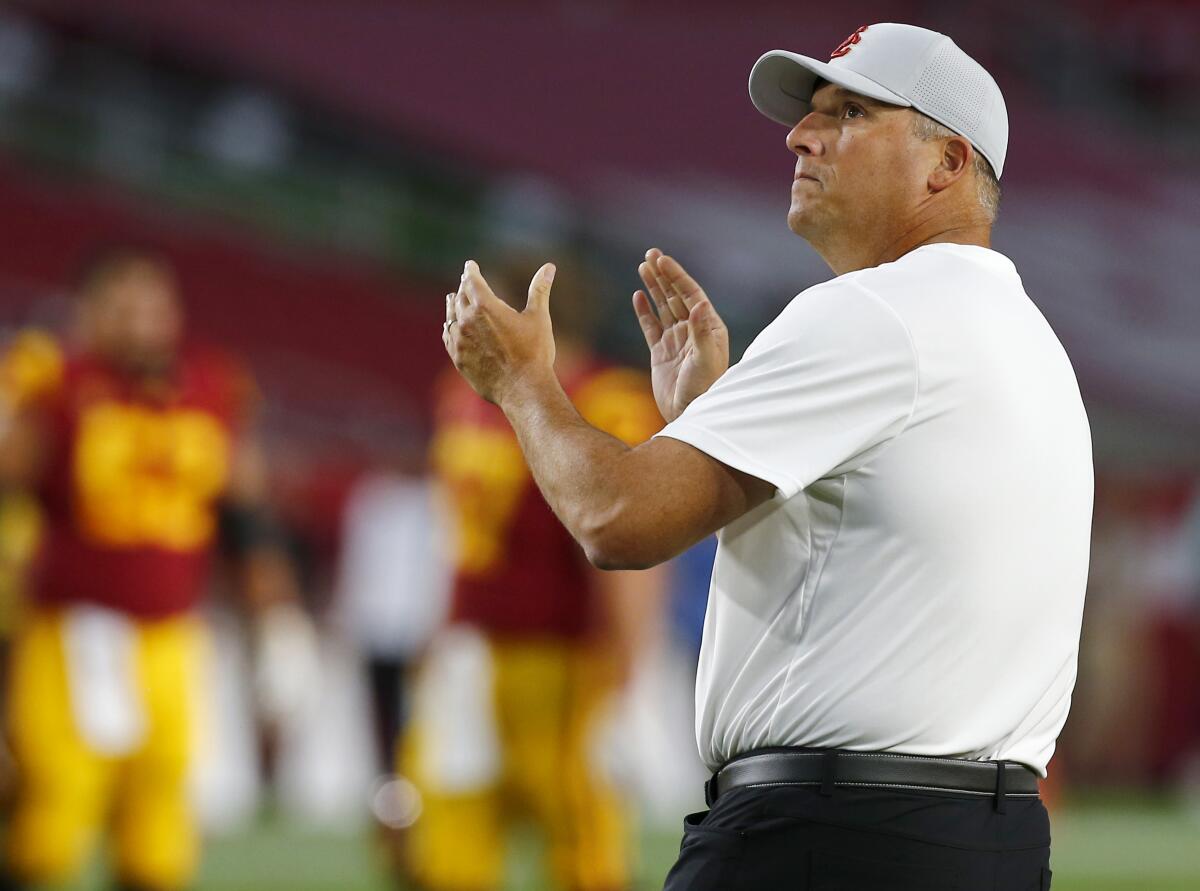 USC coach Clay Helton watches his team warm up before the game against Stanford at the Coliseum on Saturday.