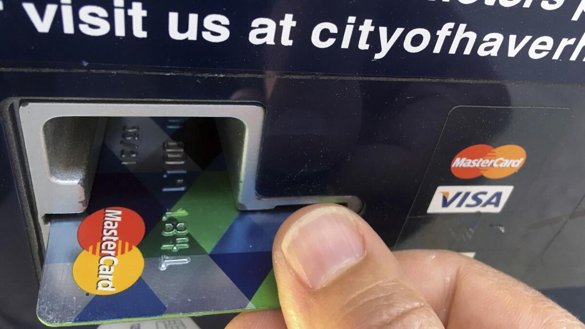 A customer pays for parking with a credit card in Haverhill, Mass., in this June 2017 file photo.