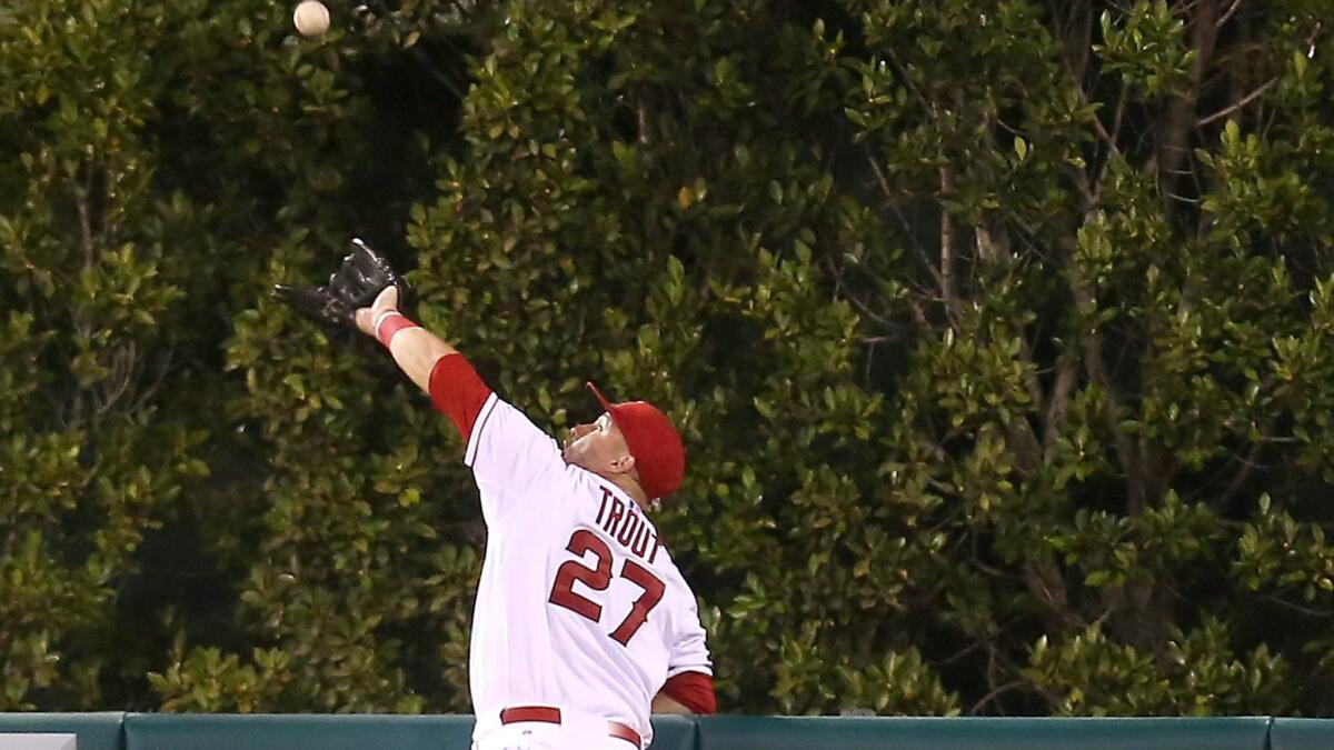 Angels center fielder Mike Trout jumps above the wall to catch a ball hit by Seattle's Jesus Montero in the fourth inning Saturday night in Anaheim.