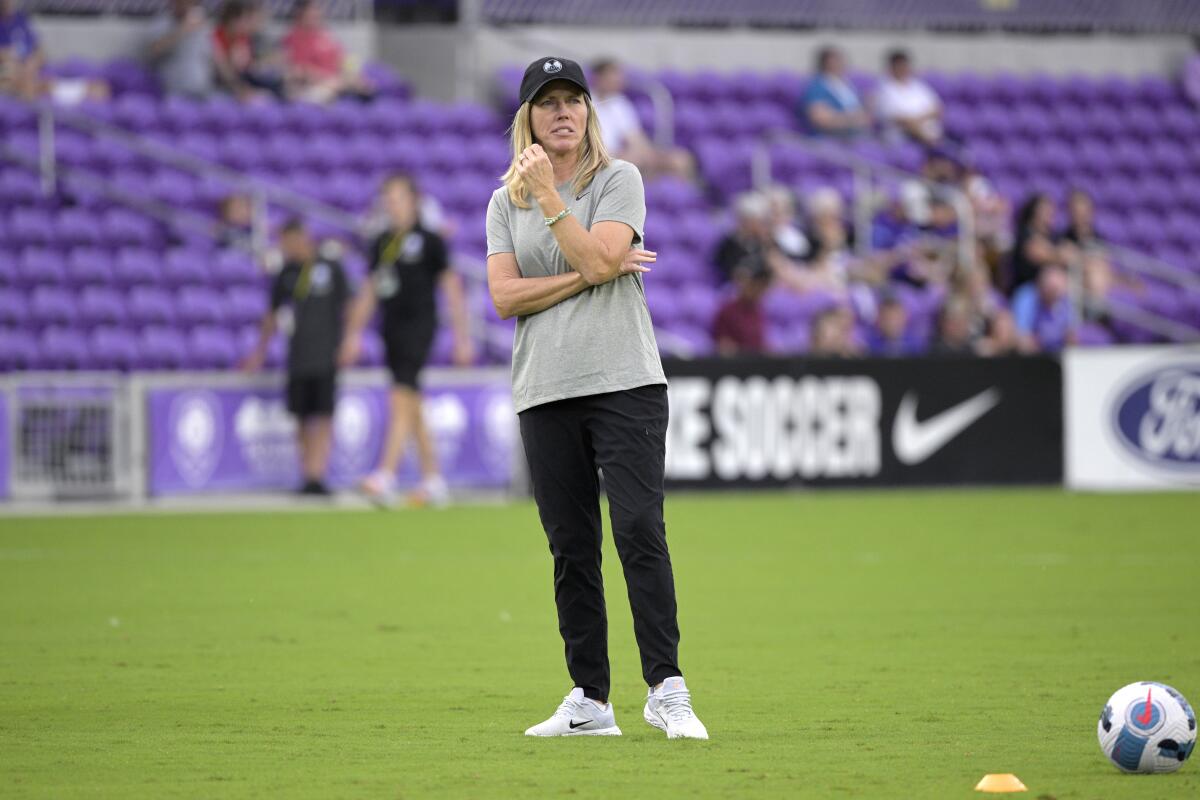 Orlando Pride coach Amanda Cromwell watches players warm up before an NWSL Challenge Cup match.
