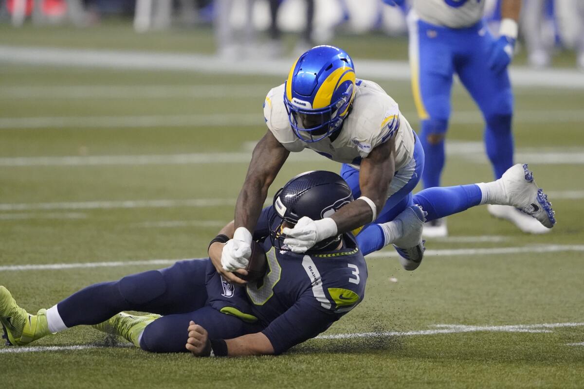 Seattle Seahawks quarterback Russell Wilson slides as he's tackled by Rams outside linebacker Leonard Floyd.