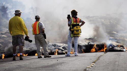 Summit explosions, toxic fumes and partial closures? That's all part of the allure as visitors flock to Hawaii Volcanoes National Park. For others, though, it's all in a day's work -- here, two park rangers and a local photographer track the advance of lava through the Royal Gardens subdivision in Kalapana.
