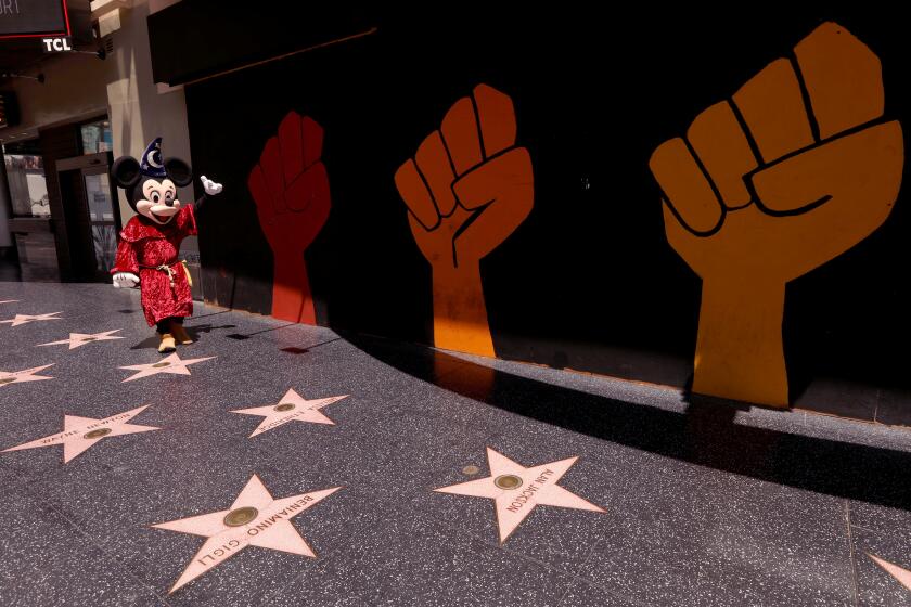 HOLLYWOOD, CA - JULY 28, 2020 - - Street performer Javei Rubio, dressed as Mickey Mouse, looks for customers to pose for photos on a deserted section of Hollywood's Walk of Fame in Hollywood on July 28, 2020. The COVID-19 pandemic has changed the landscape in LA's Hollywood/Highland corridor. (Genaro Molina / Los Angeles Times)