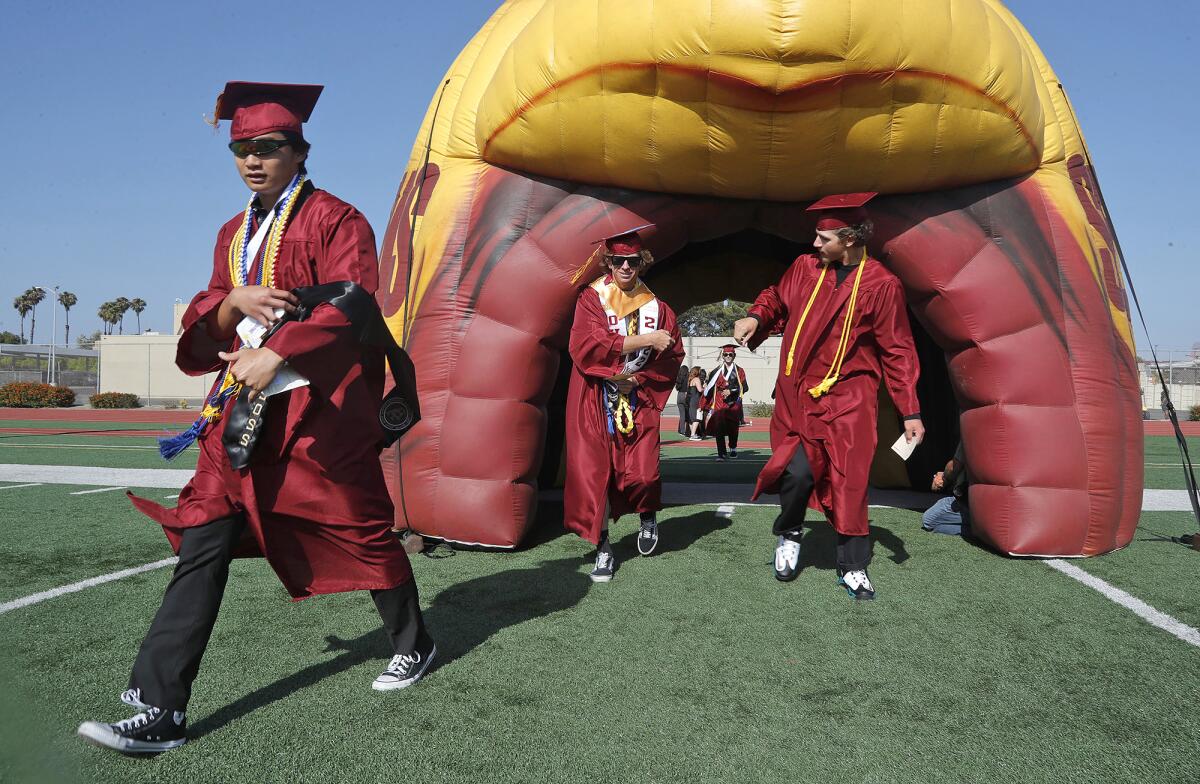 Seniors walk through the tunnel including Rizal Collado, left, during the Ocean View High graduation ceremony on Wednesday.