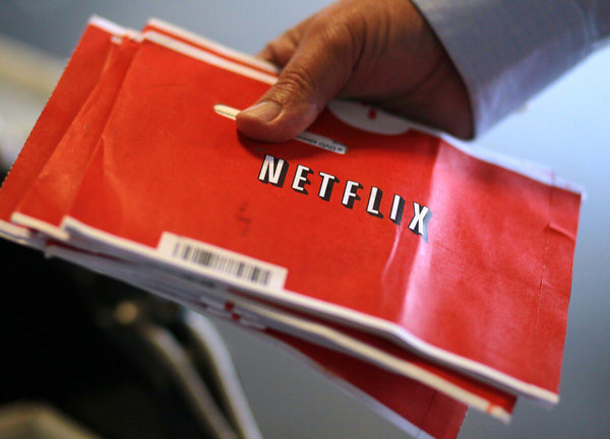A U.S. Postal worker holds a stack of Netflix envelopes at the U.S. Post Office sort facility.