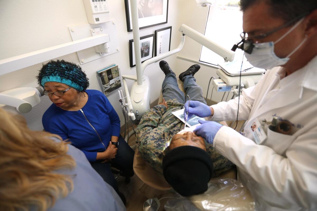 Dr. Jay Grossman, founder and chief executive of Homeless Not Toothless, gives Lawrence McCue a dental exam in Brentwood while his wife, Carla, observes. Grossman told the homeless veteran in June that it would cost $26,000 to fix his teeth and infected gums.