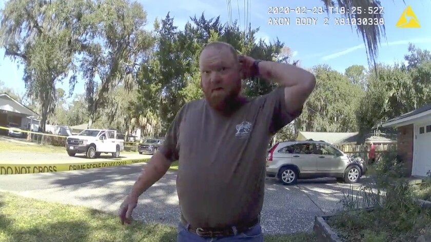 In this Feb. 23, 2020 image taken from Glynn, Ga., County Police body camera video, Travis McMichael speaks to a police officer at the scene where Ahmaud Arbery, a 25-year-old Black man, was shot and killed while while running in a neighborhood outside the port city of Brunswick, Ga. Father and son Gregory and Travis McMichael were arrested on murder charges in May, more than two months after the incident. A third man, William “Roddie” Bryan Jr., who shot cellphone video of the incident was charged with murder for joining the chase. (Glynn County Police via AP)