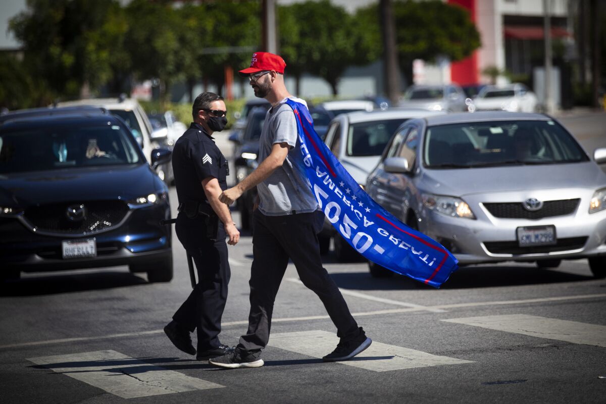 A man wearing a pro-Donald Trump cape crosses the street