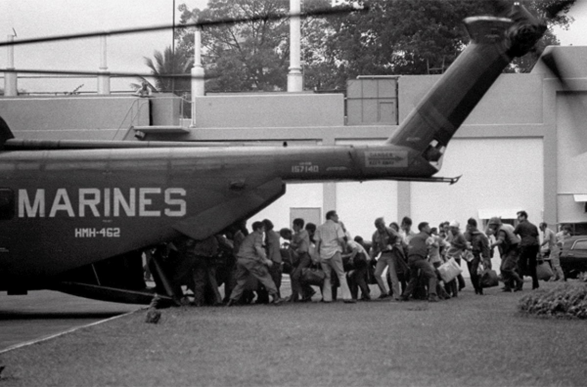 U.S. military and civilian personnel rush to board a Marine helicopter during the evacuation of the U.S. Embassy in Saigon on April 29, 1975.