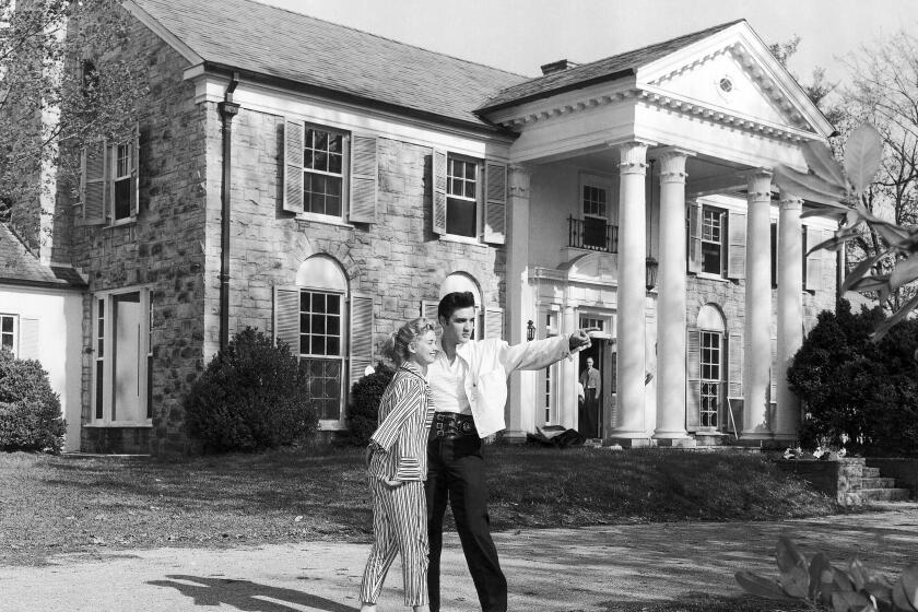 FILE - Elvis Presley with his girlfriend Yvonne Lime are photographed at his home, Graceland, in Memphis, Tenn., around 1957. A mysterious company has caused a stir for trying to auction Elvis Presley's Graceland in a foreclosure sale this week. A judge has blocked the sale after Presley's granddaughter filed a lawsuit alleging fraud. (AP Photo, File)