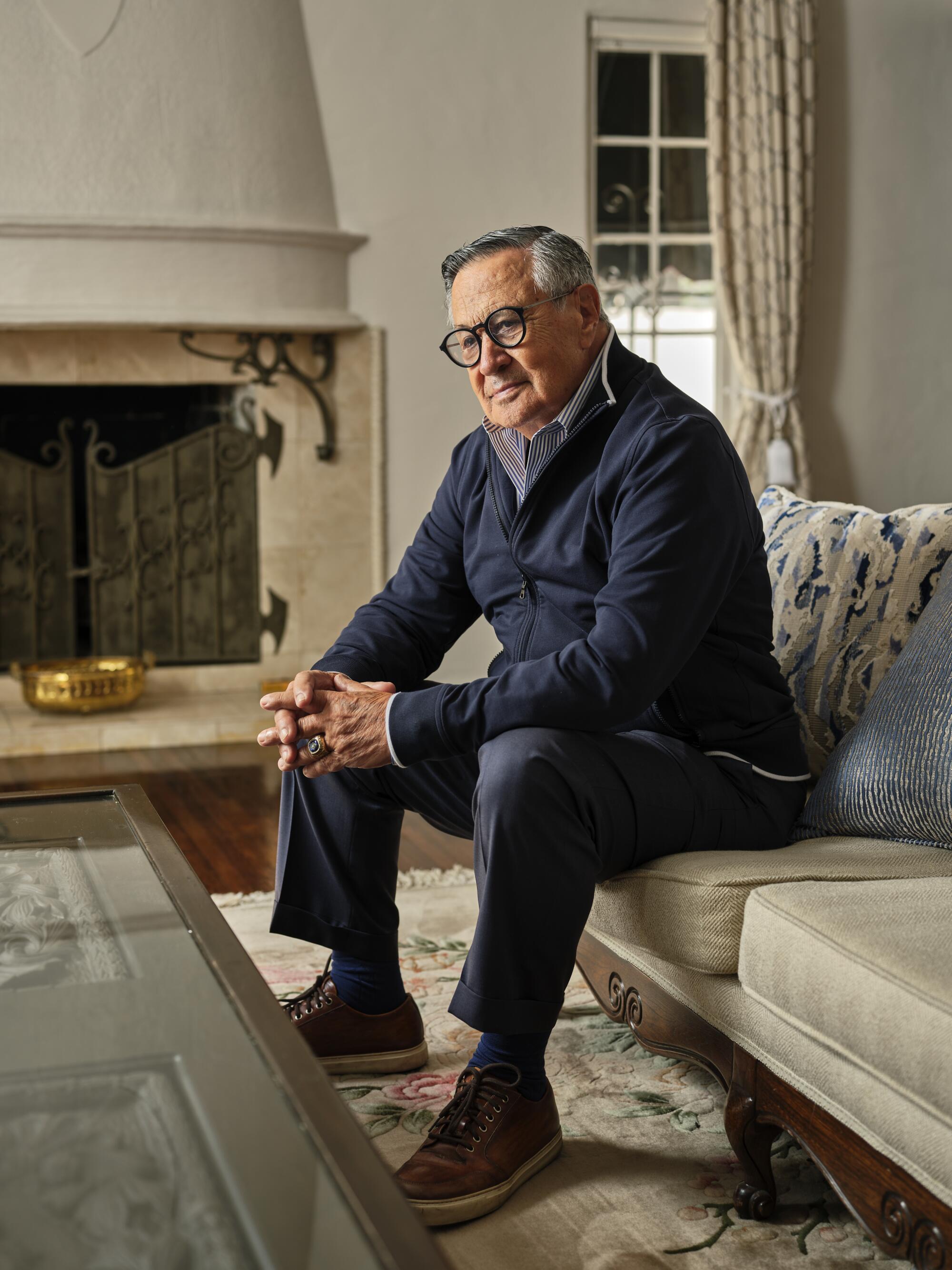 Jaime Jarrín sits on a sofa at his home.