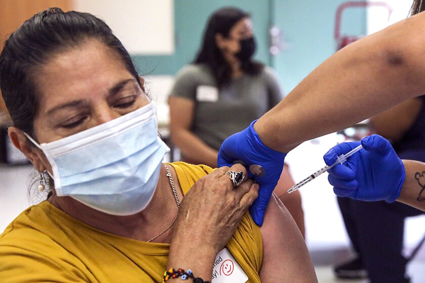 Maria Gonzalez gets a COVID-19 vaccine shot at a mobile clinic in Roosevelt Park in South L.A. on May 14.