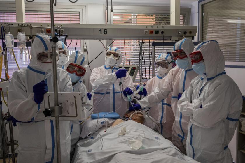 FILE - In this Friday, Oct. 9, 2020 filer, a patient infected with COVID-19 is treated in one of the intensive care units (ICU) at the Severo Ochoa hospital in Leganes, outskirts of Madrid, Spain. Intensive care space is dwindling across Europe as beds fill again with coronavirus patients, this time in places that had been spared the virus peak from last spring. (AP Photo/Bernat Armangue, File)