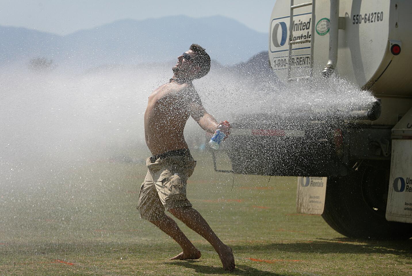 Tony Lynch, 24, of Albany, New York cools off behind a water truck after setting up his campsite, Thursday April 26, 2007.