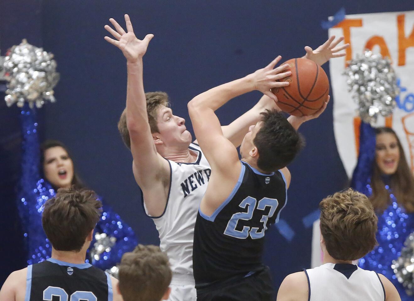 Corona del Mar High's Jack Stone drives into Newport Harbor's Will Harvey in Friday's Surf League road game. Stone had 22 points.