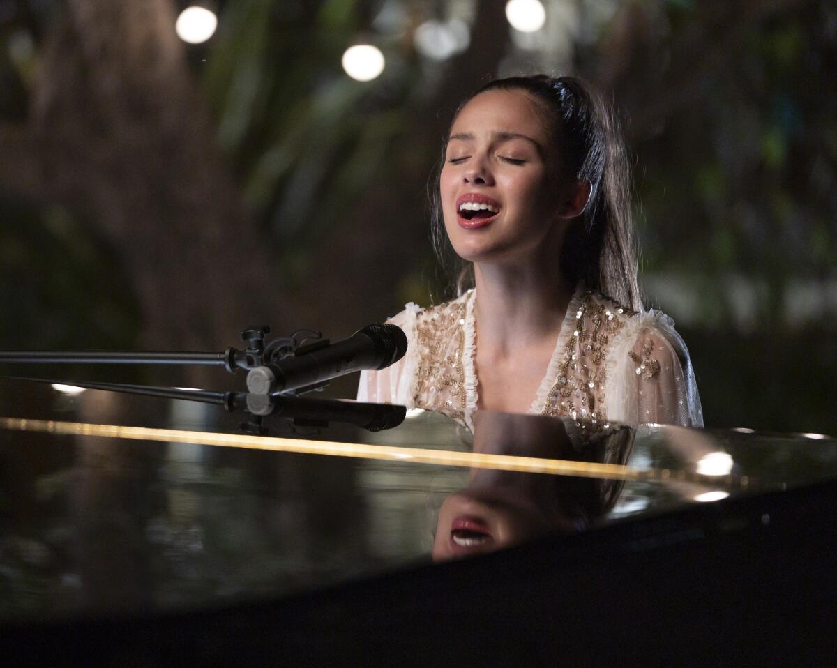 Olivia Rodrigo singing at a piano.