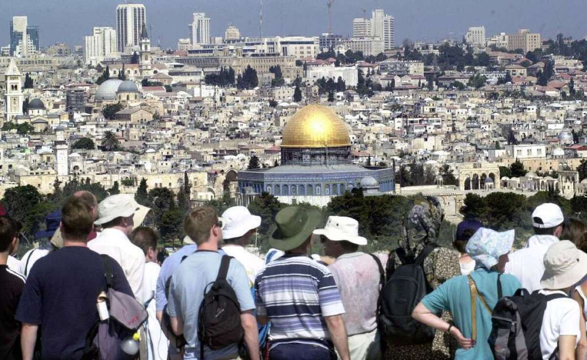 Tourists look at the Jerusalem skyline from the Mount of Olives.