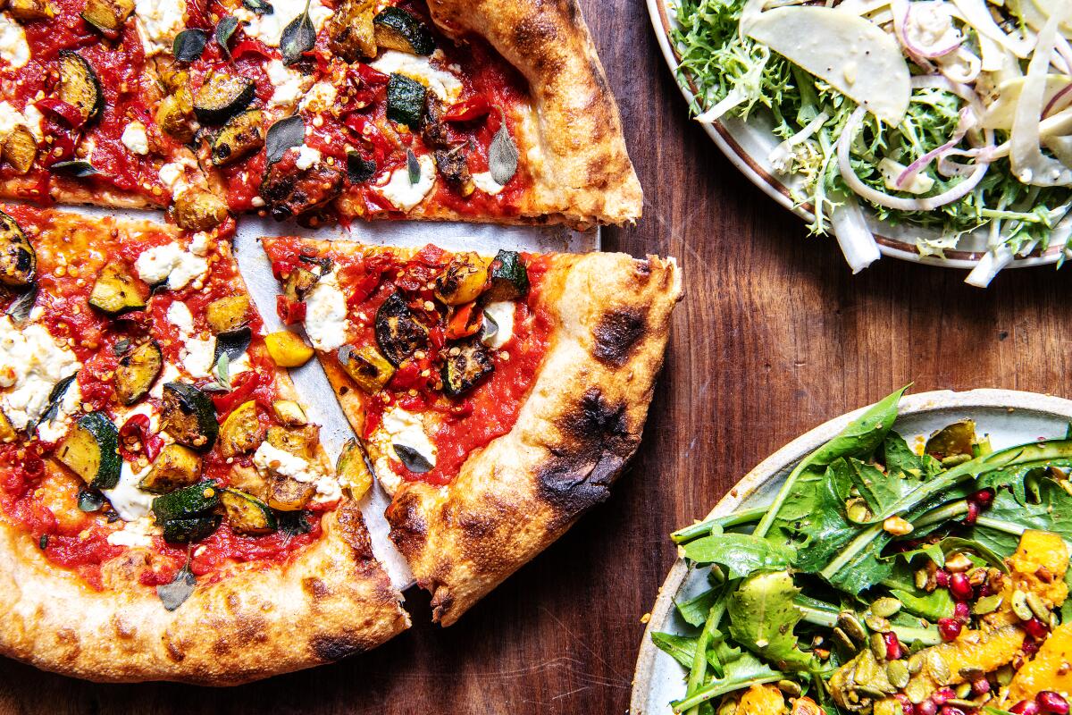 Summer squash and goat cheese pizza along with the Frisee and dandelion salads from Hail Mary on Thursday, Oct. 22, 2020 in Los Angeles.