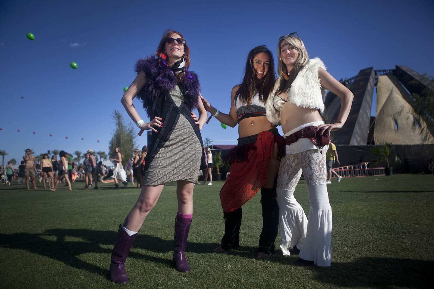 Lindsey Ackerman in purple fur and purple cowboy boots, left, Sarah Falatic and Chelsea Griggy pose together on the second day of the Coachella Music Festival.