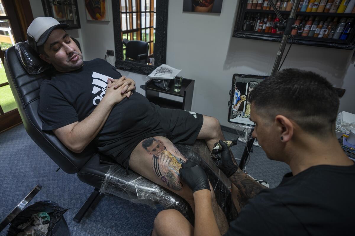 El artista César "Yeyo" Molina tatúa en la pierna de Sebastián Fernández una gran imagen del futbolista Lionel Messi