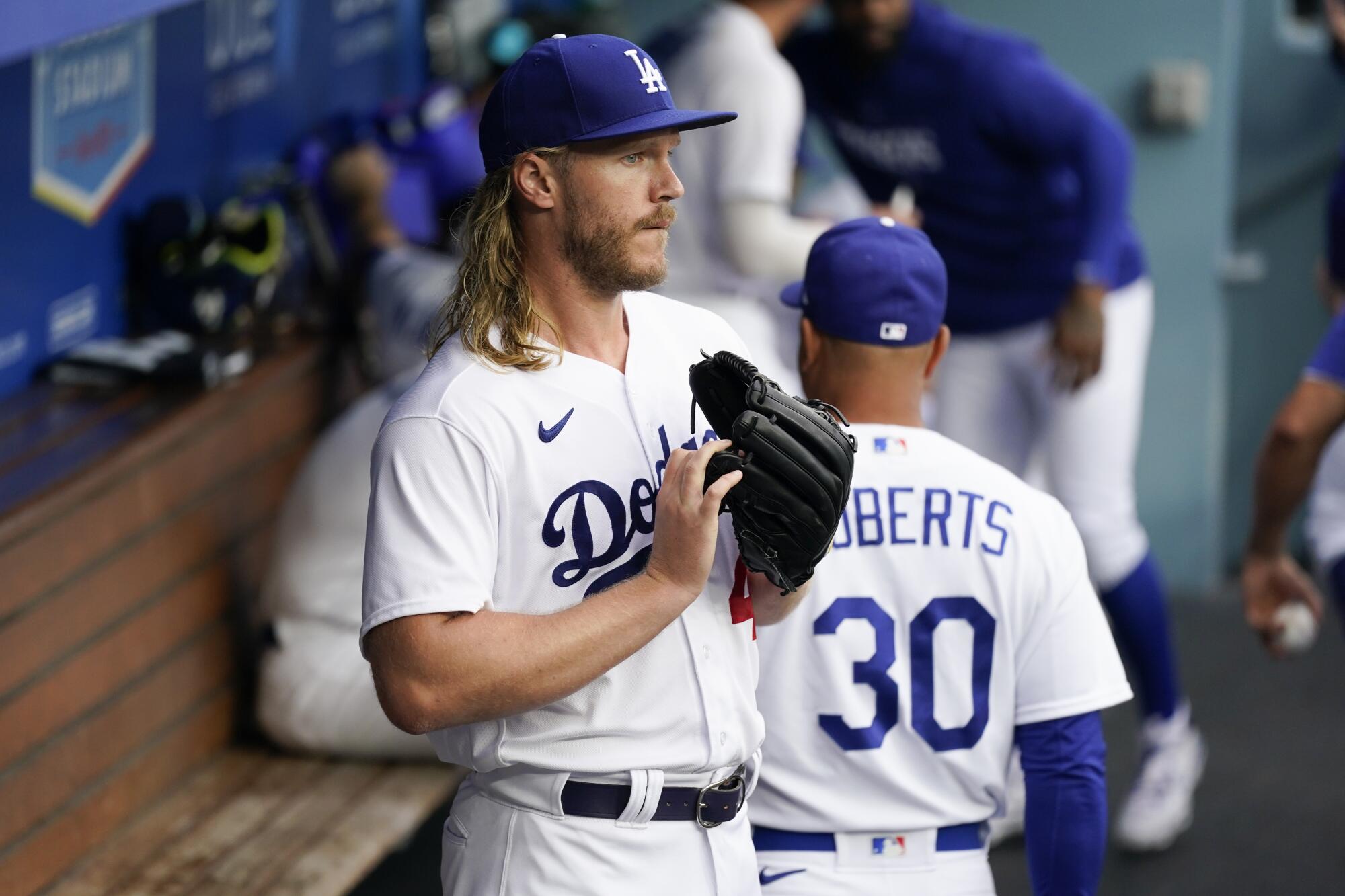 Los Angeles Dodgers starting pitcher Noah Syndergaard (43) stands in the dugout before a baseball game.