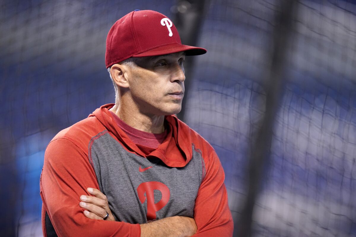 FILE - Philadelphia Phillies manager Joe Girardi watches as players warm up before a baseball game against the Miami Marlins, Friday, Oct. 1, 2021, in Miami. Girardi isn’t concerned about managing the Philadelphia Phillies without a contract extension. Girardi signed a three-year deal in 2019 with a team option for 2023. The club hasn’t picked up the option and will likely wait to make that decision. (AP Photo/Lynne Sladky, File)