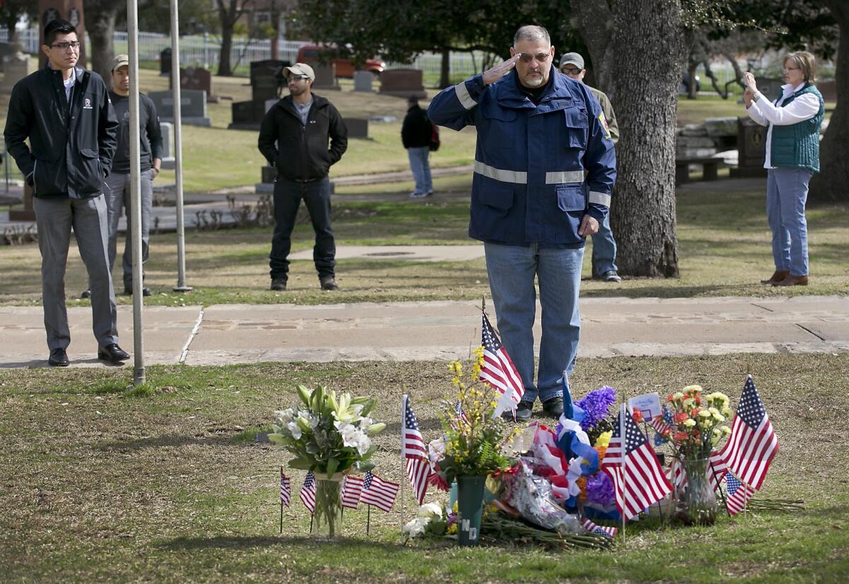 The fame of "American Sniper" author Chris Kyle could complicate jury selection for the trial of the man accused of killing him and a friend. Above, Army veteran Alex Barragan visits Kyle's grave in Austin on Feb. 2, the second anniversary of his death.