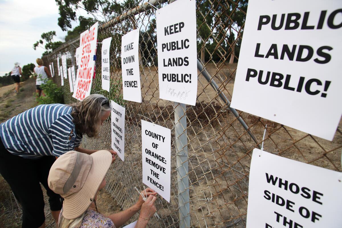 Protestors put signs on the fence demonstrating against the fence still being up.