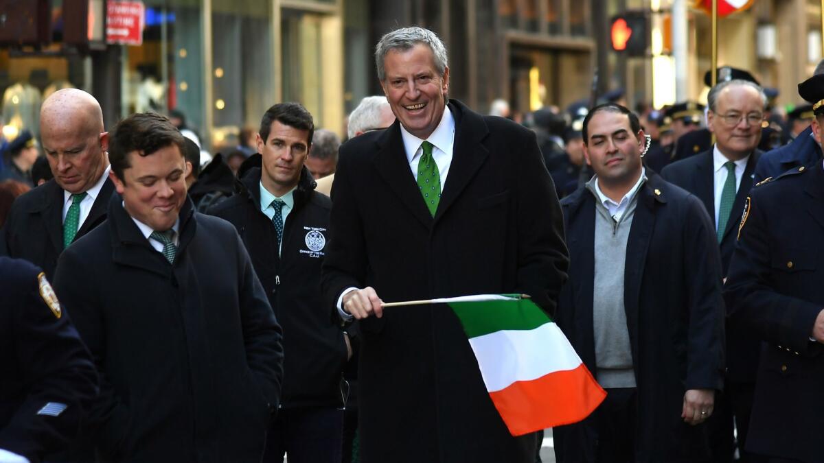 Mayor Bill de Blasio carries an Irish flag while marching in the annual St. Patrick's Day parade Saturday in New York City.