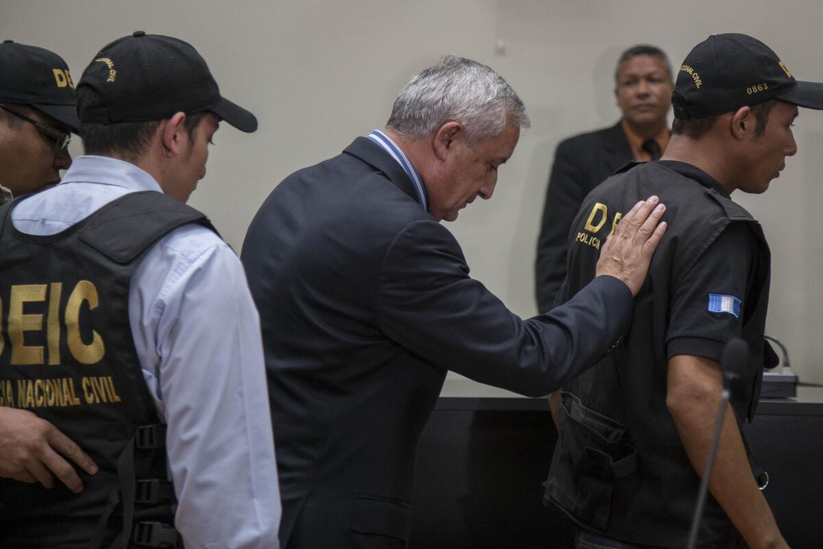 El ex presidente de Guatemala, Otto Pérez Molina (centro), es escoltado por agentes de la policía antes de ingresar en prisión, (Foto AP/Luis Soto)