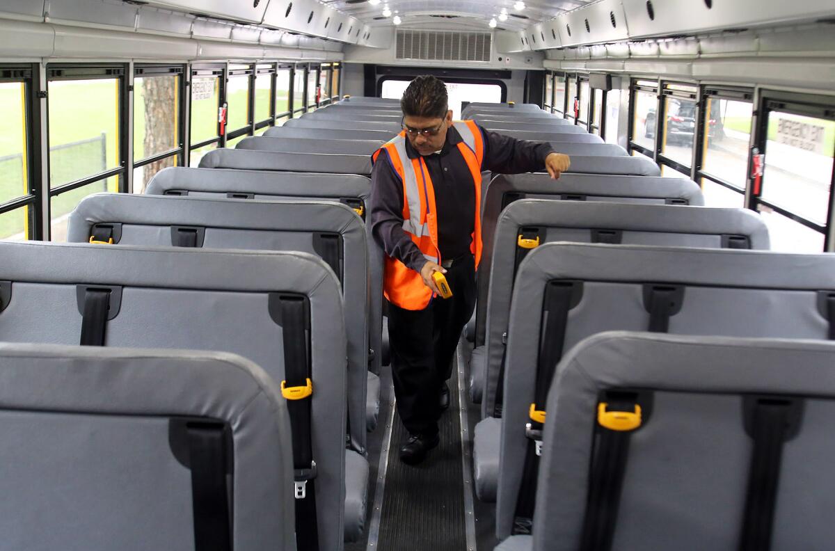 Joaquin Arias, a safety specialist with First Student Bus Co., demonstrates the new child-safety check system on a First Student school bus parked at Johnny Carson Park in Burbank on Monday. First Student Bus visited Burbank to teach about bus safety.