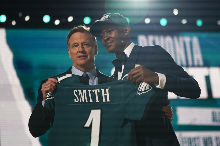 Alabama wide receiver DeVonta Smith, right, holds a team jersey with NFL Commissioner Roger Goodell after he was chosen by the Philadelphia Eagles with the 10th pick in the first round of the NFL football draft Thursday, April 29, 2021, in Cleveland. (AP Photo/Tony Dejak)
