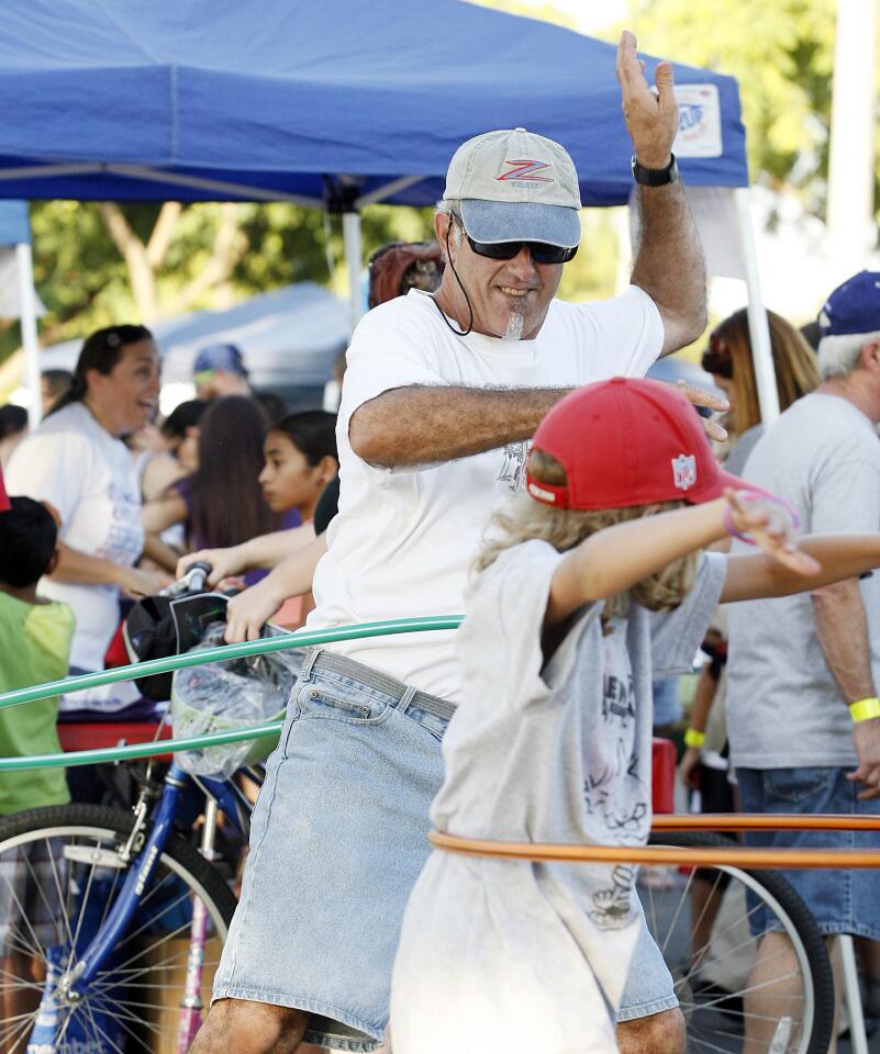 Art Russo, of Burbank, competes with his son Nick, 9, with a hoola hoop at the annual National Night Out hosted by Burbank Police and the city¿s Park, Recreation and Community Services department on the Chandler Bikeway.
