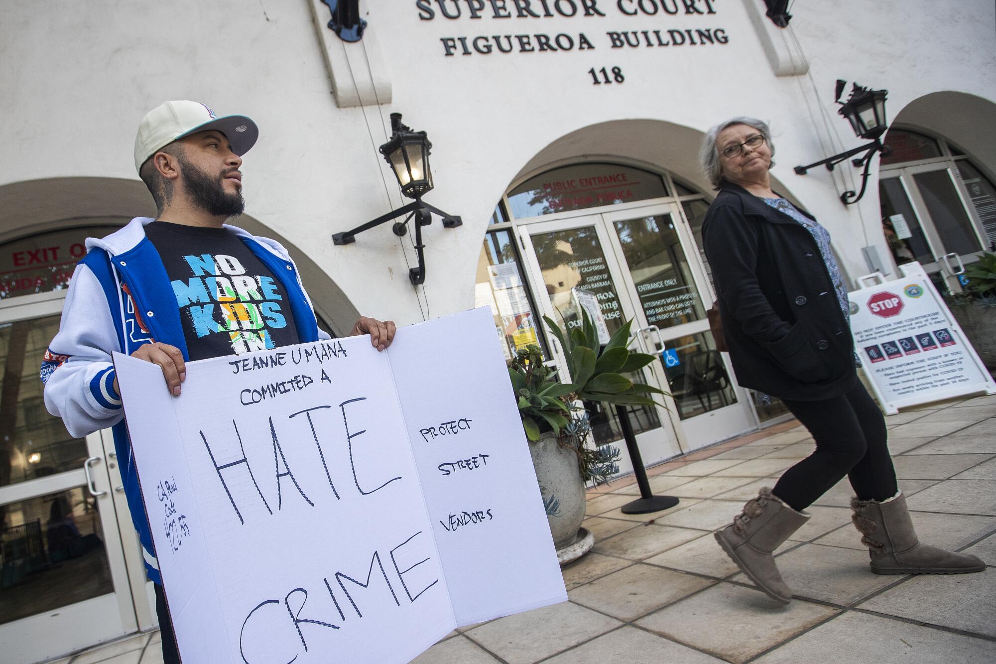 A man with a sign  protests outside of Santa Barbara County Superior Court