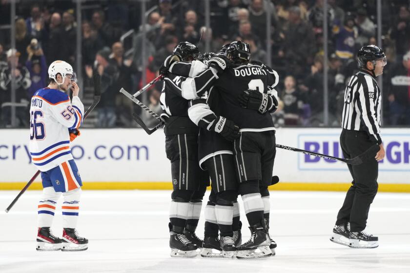 Kings players celebrate an open-net goal by Viktor Arvidsson as Edmonton Oilers' Kailer Yamamoto (56) skates past them