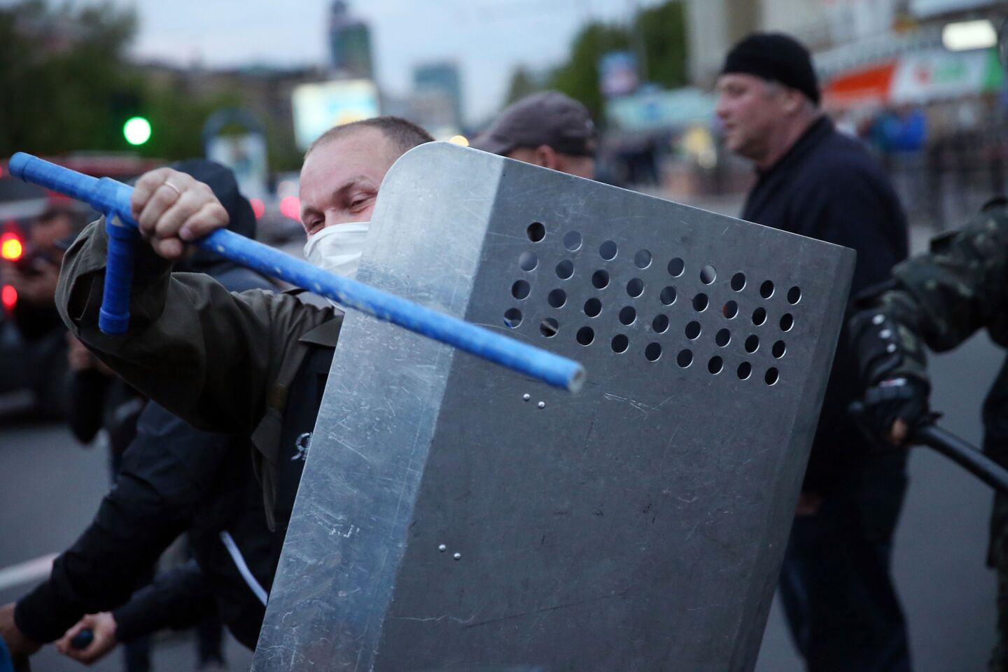 A pro-Russian activist beats his shield as the activists regroup after clashing with pro-government supporters during a rally and march in Donetsk, Ukraine.